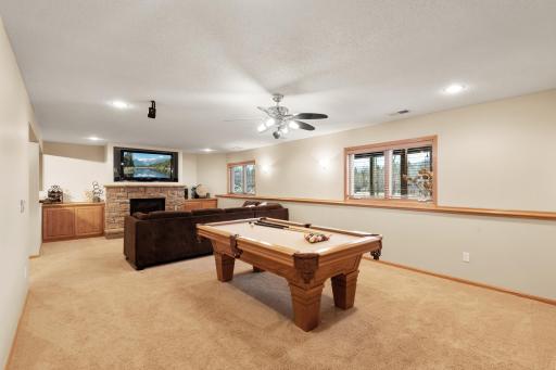 A perfect recreation room off the lower level bar/kitchen area is finished off with a stone gas fireplace for the perfect ambiance.