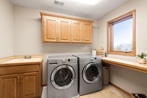 Main floor laundry room with convenient folding area, storage space, tile floors for easy maintenance and a wonderful window overlooking the back yard.