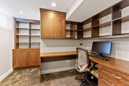 Basement home office with custom built-in desk and cabinets.