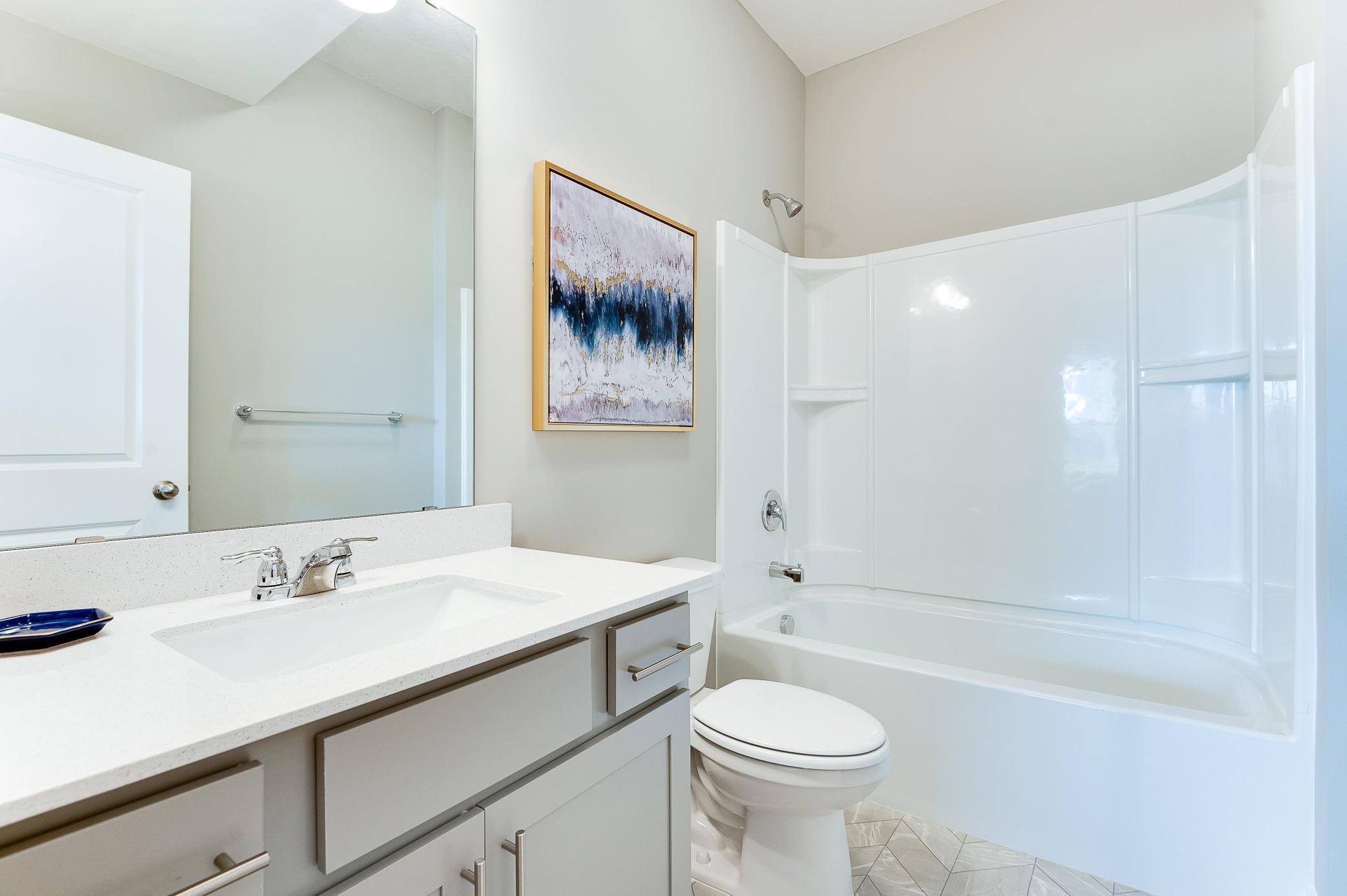A peak inside the private bathroom in the main level guest suite! Photo of model home, color and options will vary.