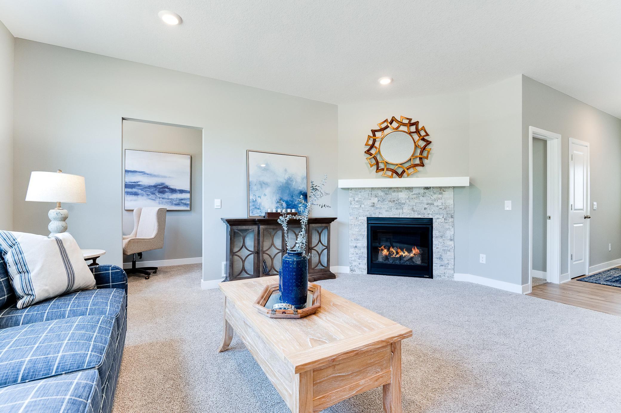 The gas fireplace situated in the corner of the living room provides a warm ambience. Photo of model home, color and options will vary.