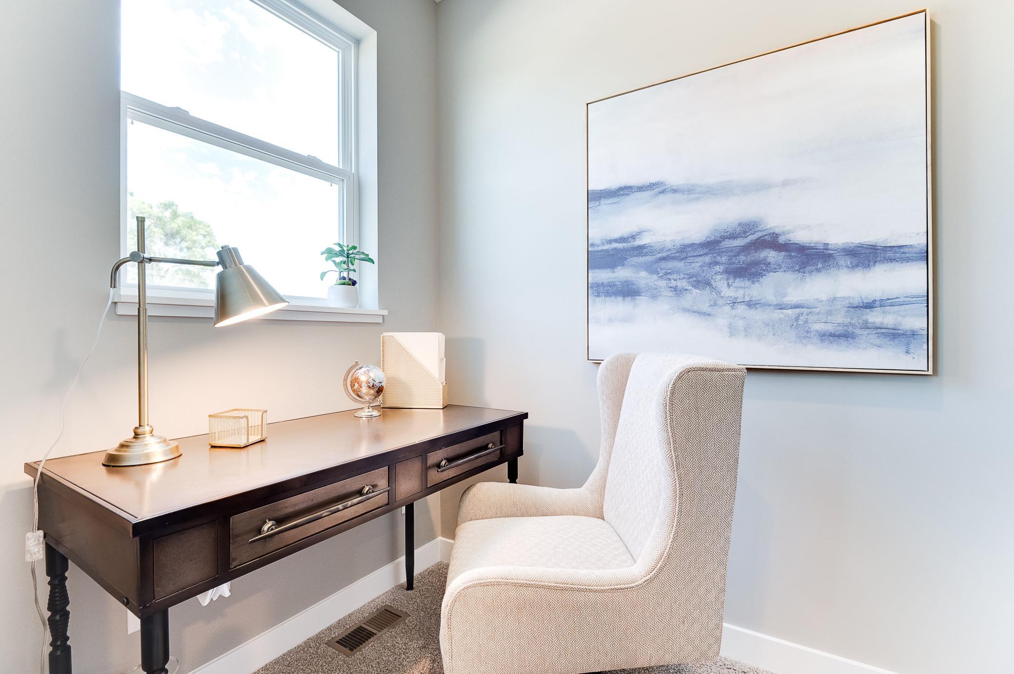 Tucked off the very far end of the main level, this pocket-style office offers the perfect setting for a homework spot or office locale for those working from home! Photo of model home, color and options will vary.