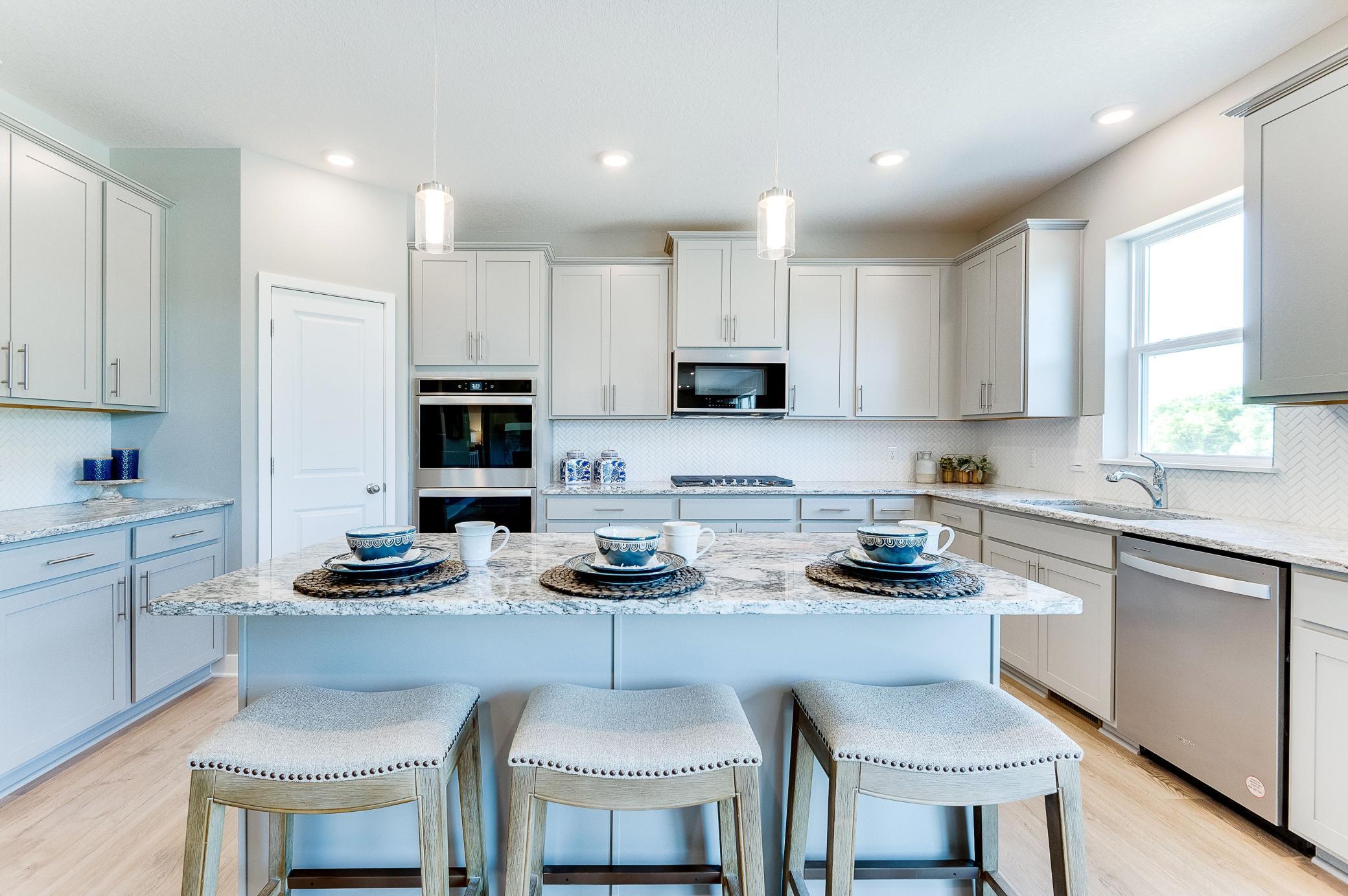 A kitchen that is equal parts open and inviting throughout, the space will be the focal point of gatherings for years to come! Photo of model home, color and options will vary.