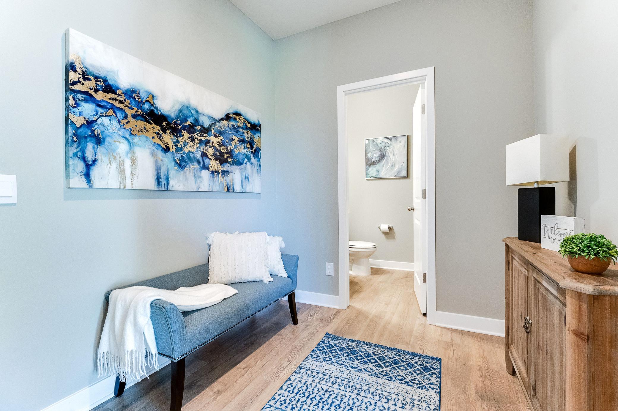 The home's entrance off the garage leads to this mudroom space, which (like the rest of the main level) is wide open and features both a large coat closet and powder room bath! Photo of model home, color and options will vary.
