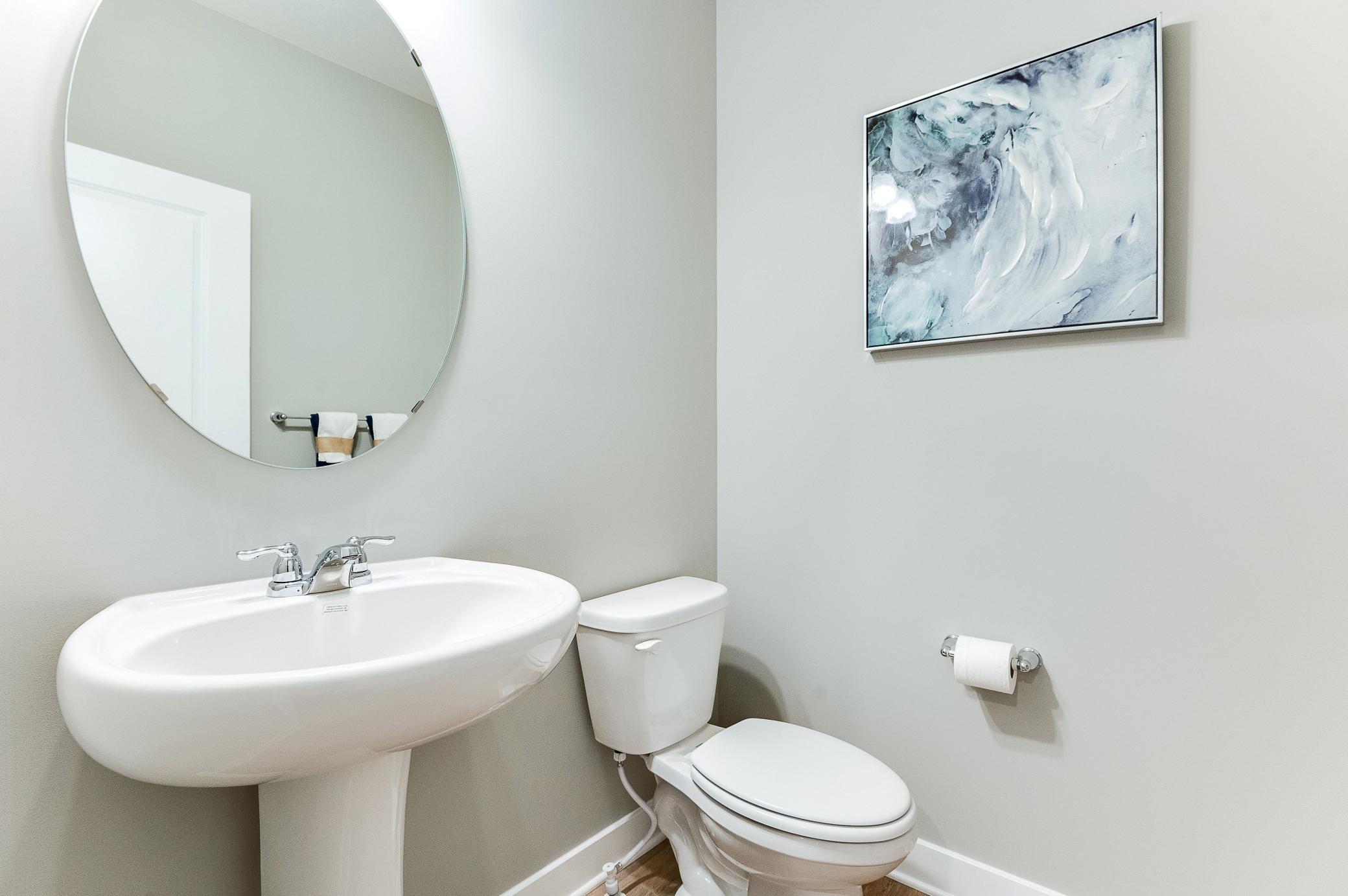 Powder bath is conveniently located on the main level, just tucked away out of the kitchen. Photo of model home, color and options will vary.