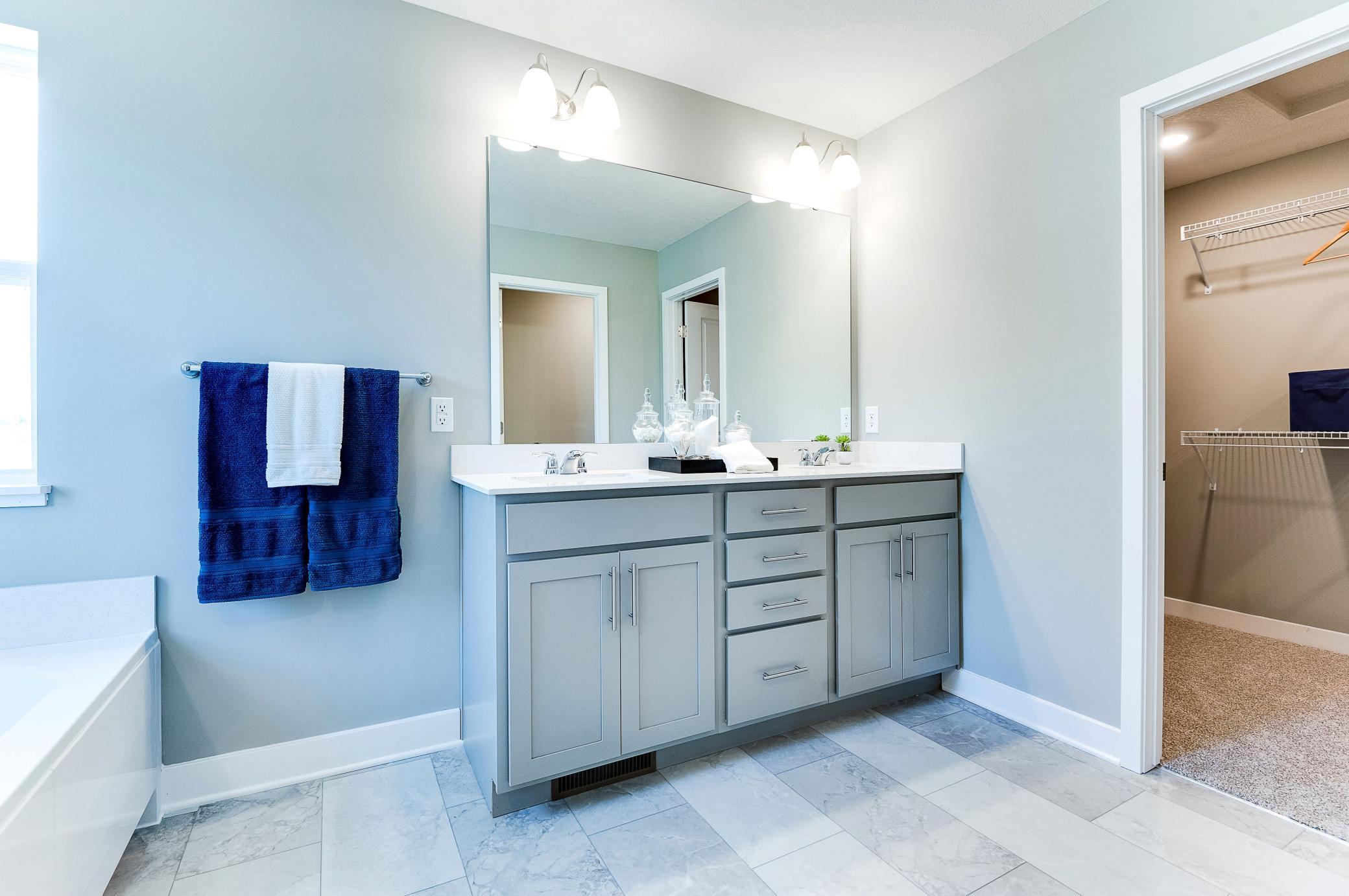 An extension of the primary suite, this private and spacious bathroom contains a double-vanity, an oversized stand-in shower, soaking tub, private stool room and access to a HUGE walk-in closet!! Photo of model home, color and options will vary.