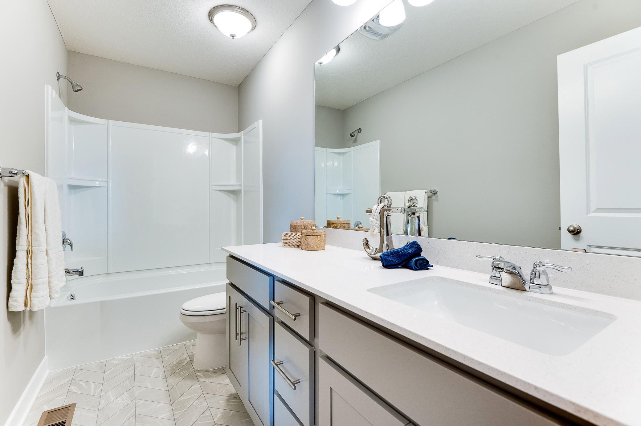 Those bedrooms are serviced by this full bath! Photo of model home, color and options will vary.