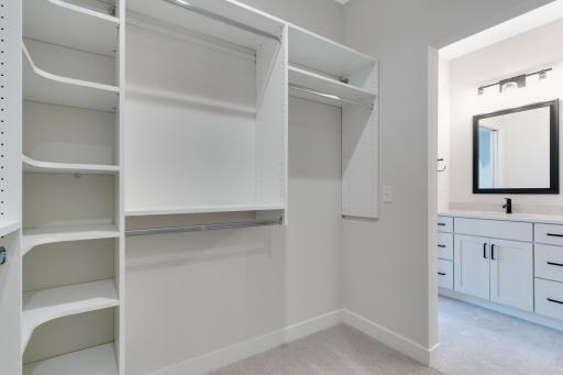 Large Primary Bedroom walk-in closet w/ custom built shelving.
