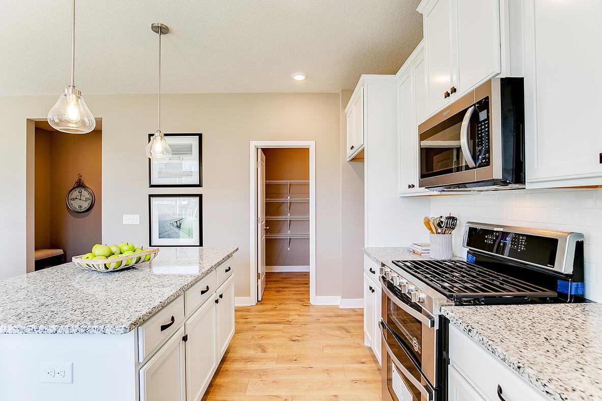 Built to perform, not a single element was missed. Stunning stainless steel appliances, Granite coated countertops (including the massive island) & an extra-deep pantry! What time is dinner!? Photo of model home, color and options will vary.