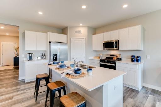 A stunning kitchen layout, all while remaining remarkably functional: The quartz is endless, the sink is under-mounted, the range is gas, the micro-hood is vented to the exterior of the home! Photo of model home, color & options may vary.