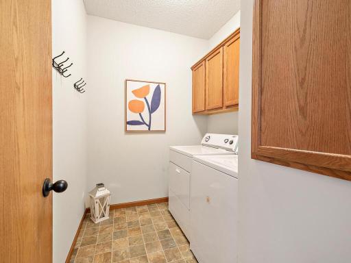 Laundry room has good storage cabinets with full-size washer and dryer.