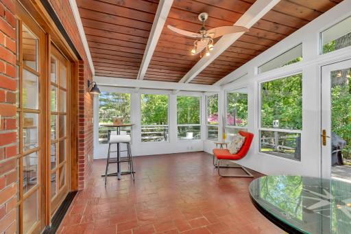 The three season porch/sun room features beautiful tiled flooring, gorgeous brick wall, exposed wood beams, access to the dining room, living room, deck/balcony and windows!!