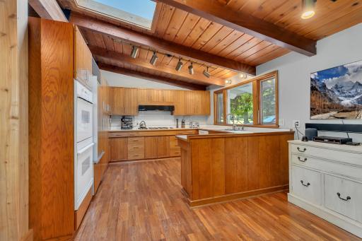 This amazing kitchen features oak hardwood flooring, exposed wood beams, skylight, integrated Sub-Zero refrigerator, Dacor double wall oven, six burner stove...