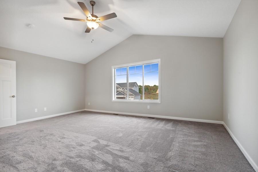 Check out this expansive owner's suite with vaulted ceilings, ceiling fan, and great picture window!
