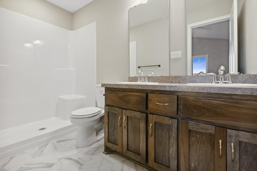 Private owner's suite bathroom with double vanity, custom cabinetry and oversized shower.