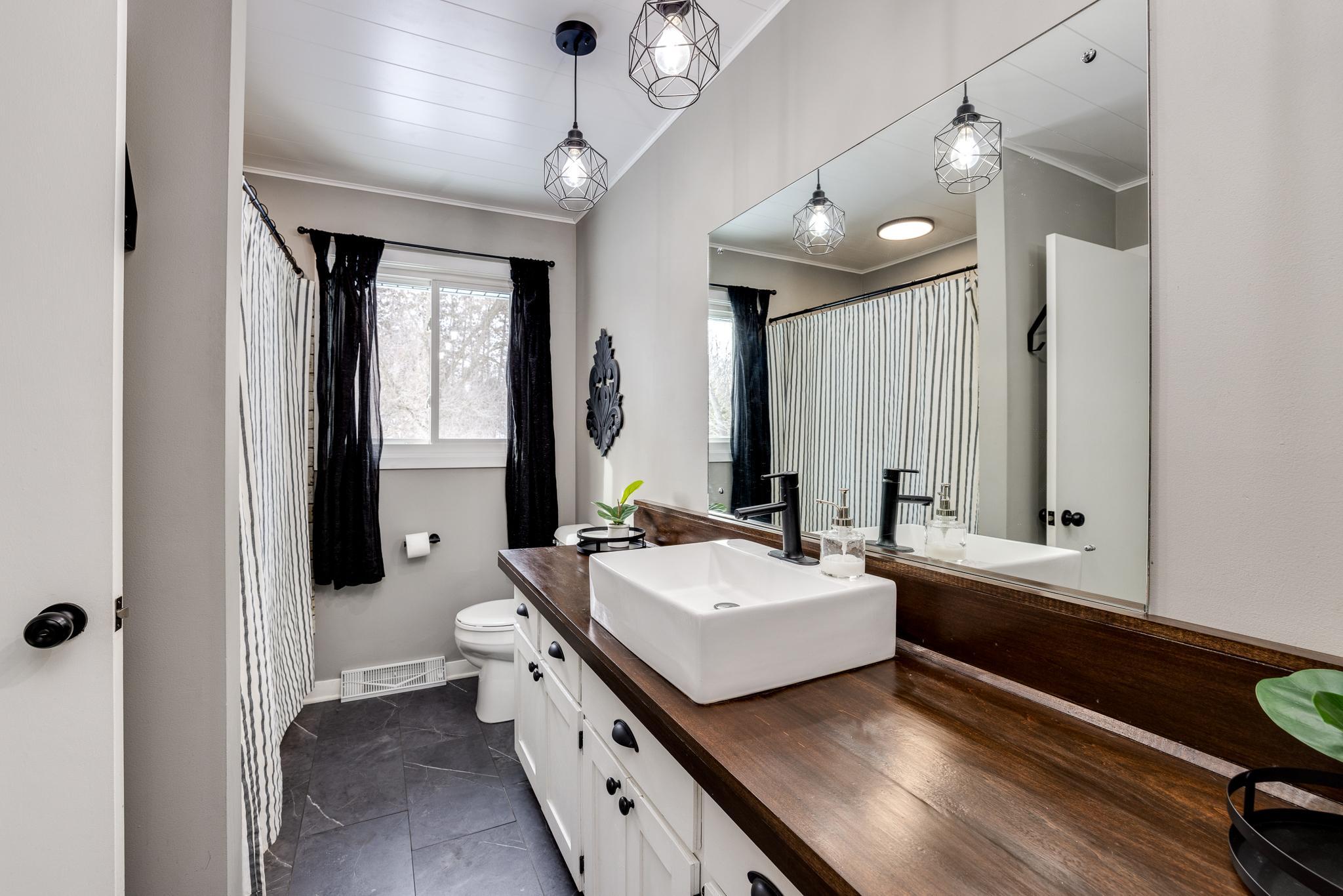 Amazing bathroom- custom countertops, paneled ceiling, designer lighting, tiled floors and more!