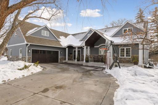 Beautiful 2-story Edina home with large stamped concrete driveway, custom garage door, quaint front porch, and stone detailing.