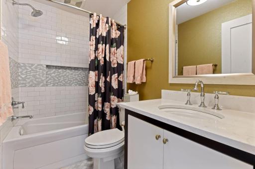 Junior suite bathroom with a full tub, Cambria countertops, and beveled wallpaper.