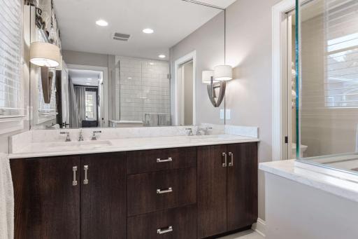 Master bath with custom double vanity with Cambria countertops, separate toilet room, and large shower with frameless glass.