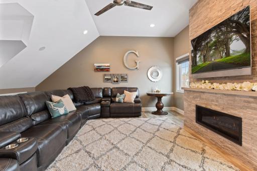 The room is large enough for a sectional that seats 8. A modern gas fireplace nestled into a stone wall is a stunning feature that completes the look.