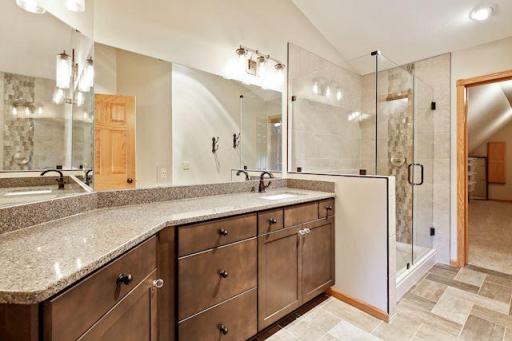 Spa like bathroom with tile floors, large walk in shower & lots of cabinet space.