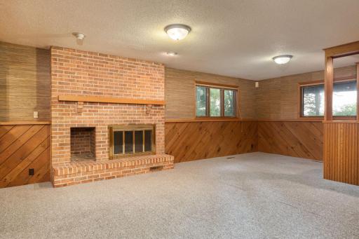 Lower level Amusement Room with wood-burning brick fireplace.