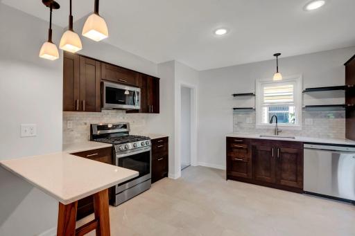 The kitchen has been thoughtfully renovated, with comfortable vinyl plank floors for easy cleaning and a cute breakfast bar. Just pull up a stool!