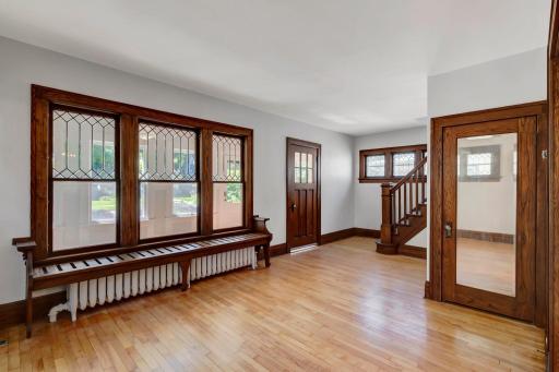The living room has a cute bench over the radiator, and features beautiful leaded glass windows that open to the sunroom. Great cross-ventilation!