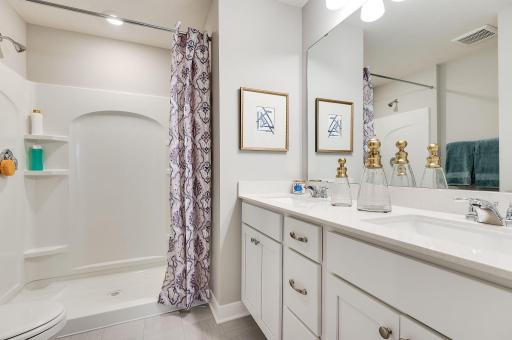 In addition to the space provided in the primary bedroom, the attached bath provides a true oasis to come home to, featuring a double vanity and stand-in shower. Photo of model, colors and options will vary.