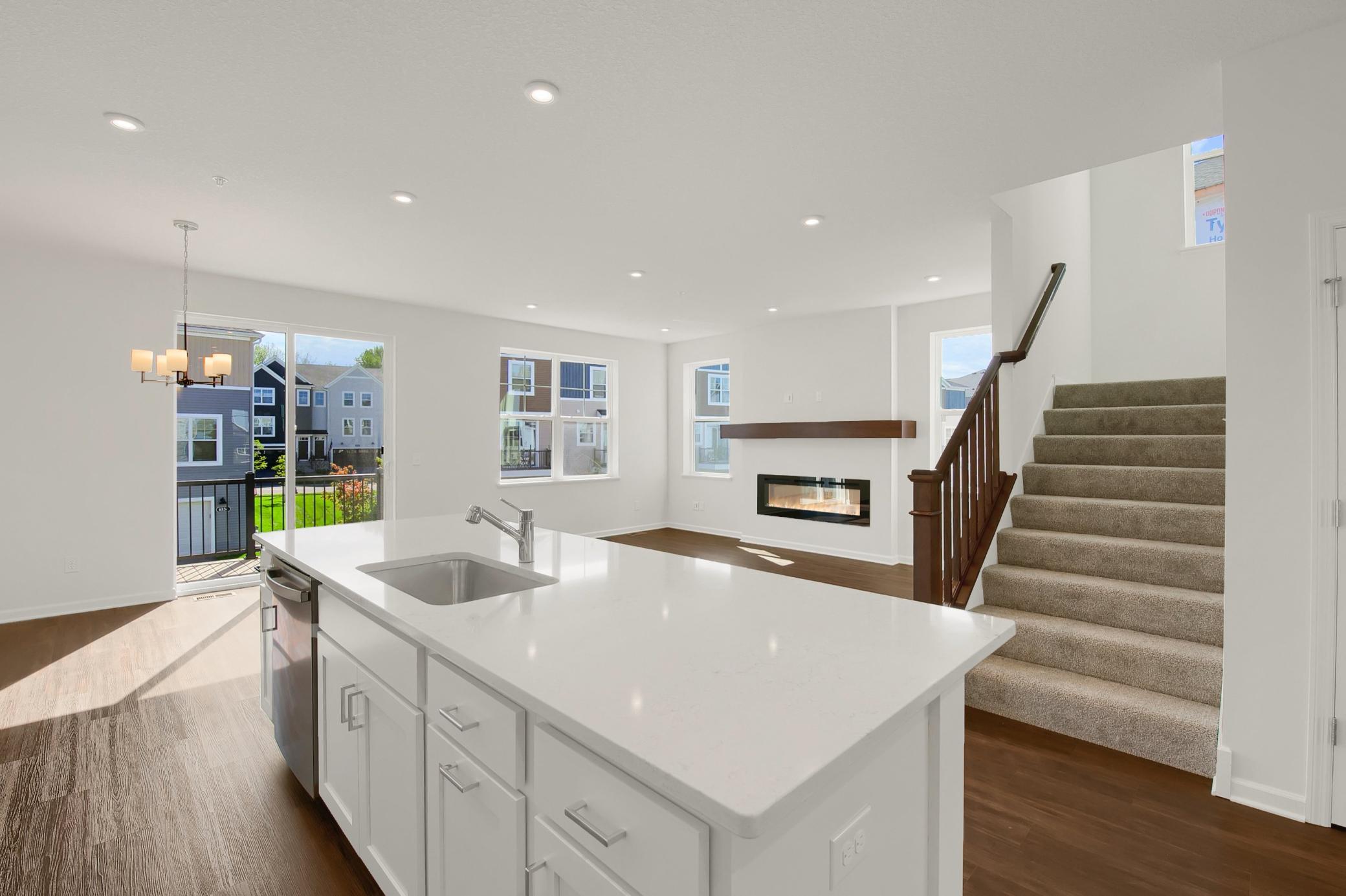 The kitchen overlooks the dining and family room of the open main floor plan design.