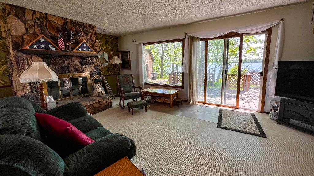 11036 Tall Timbers Rd SW, Garfield, MN 56332 Large living room and a wall of glass for view of Lobster Lake. The wood burning fireplace will make this one even better in the off seasons!