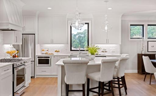 Well-designed, the kitchen features a large island with counter seating. Photos of similar model.