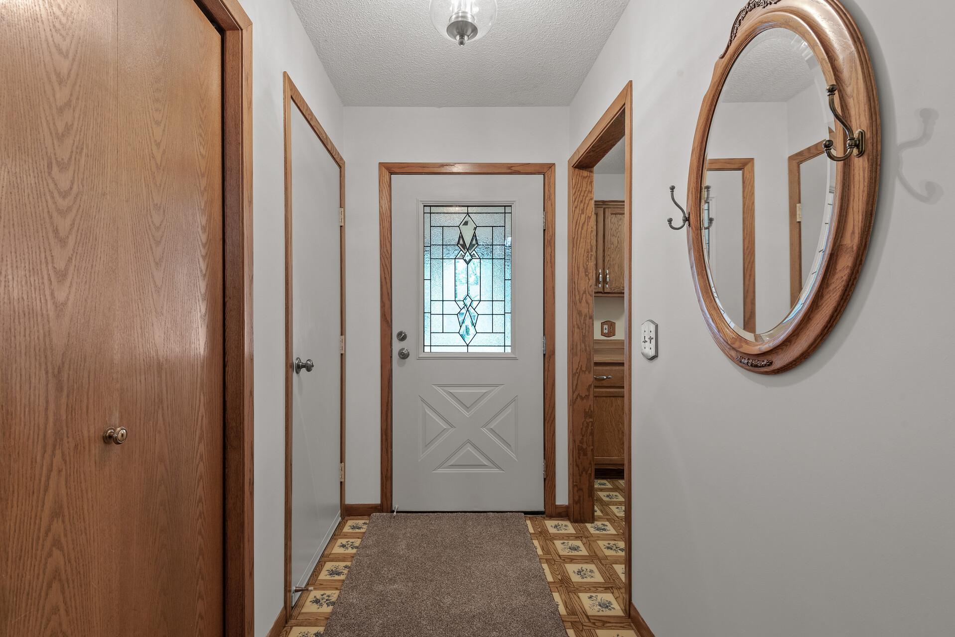Entry way leads to kitchen, garage door and coat closet