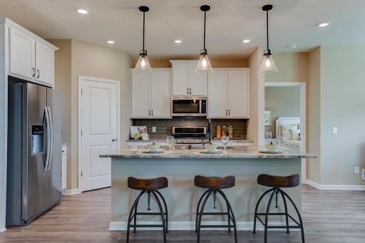 The kitchen has ample counter space (including seating at the island!) and lots of cabinet space. The perfect space for making everyday meals or memorable special occasion dinners.... *Photo of previous model home, selections will vary
