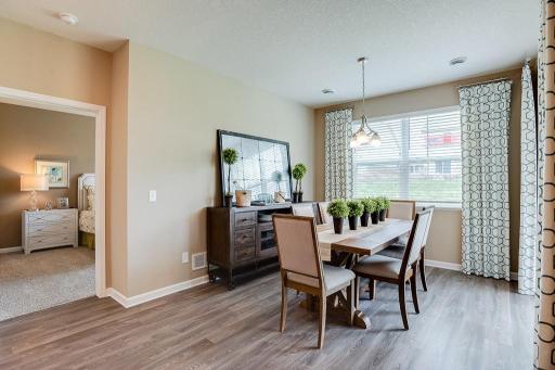 Grab a meal at the island, or utilize this dining space - which features soaring windows allowing plenty of natural light to stream into the space and overlooks the home's deck! *Photo of previous model, selections will vary.