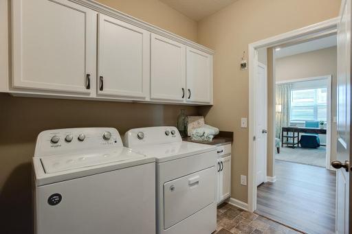 Another feature in the home is this main level laundry room, complete with cabinets! *Photo of previous model, selections will vary.