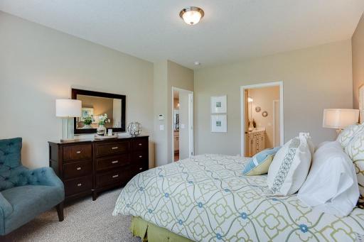 Another view of the primary suite, and the access point to the primary suite bath - which is loaded with amenities and connects directly to a massive walk-in closet! *Photo of previous model, selections will vary.