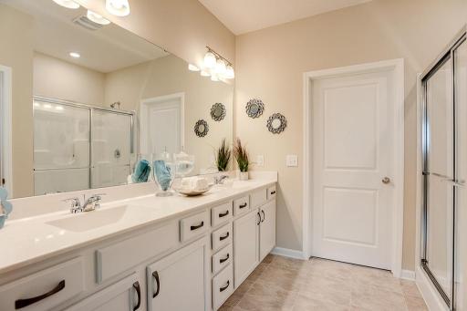 Tucked back adjacent to the primary suite, this oversized bath features a walk-in shower, and 36-inch high dual vanities - plenty of storage! *Photo of previous model, selections will vary.