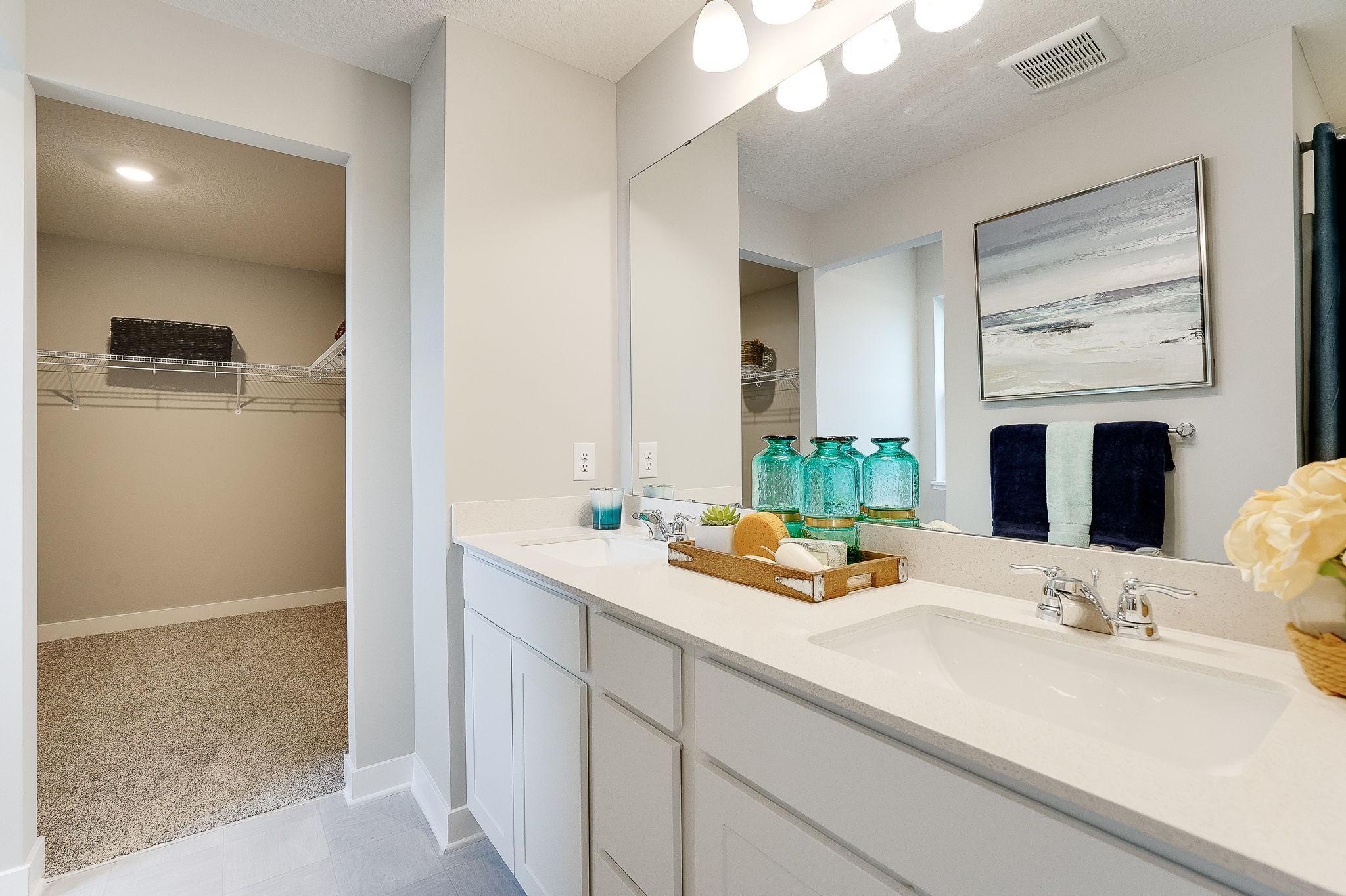 The attached primary bathroom makes getting ready to go fun! It features a double quartz vanity, linen closet, walk-in shower and separated toilet. (Model home, colors will vary)