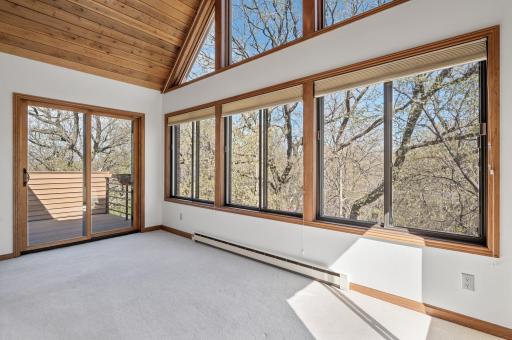 Beautiful four-season porch with tons of windows allowing tons of natural light to pour in, 16-foot vaulted tongue & groove ceilings + access to the deck.