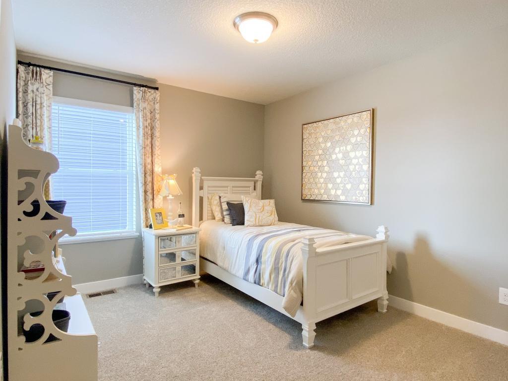 In addition to the primary bedroom, the home's upper level also includes these two additional bedrooms, and another full bathroom just adjacent to each! Photo of model, colors will vary