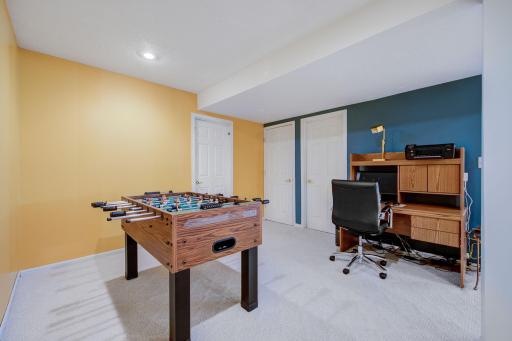 Lower level recreation room with access to storage and the utility room through the doors
