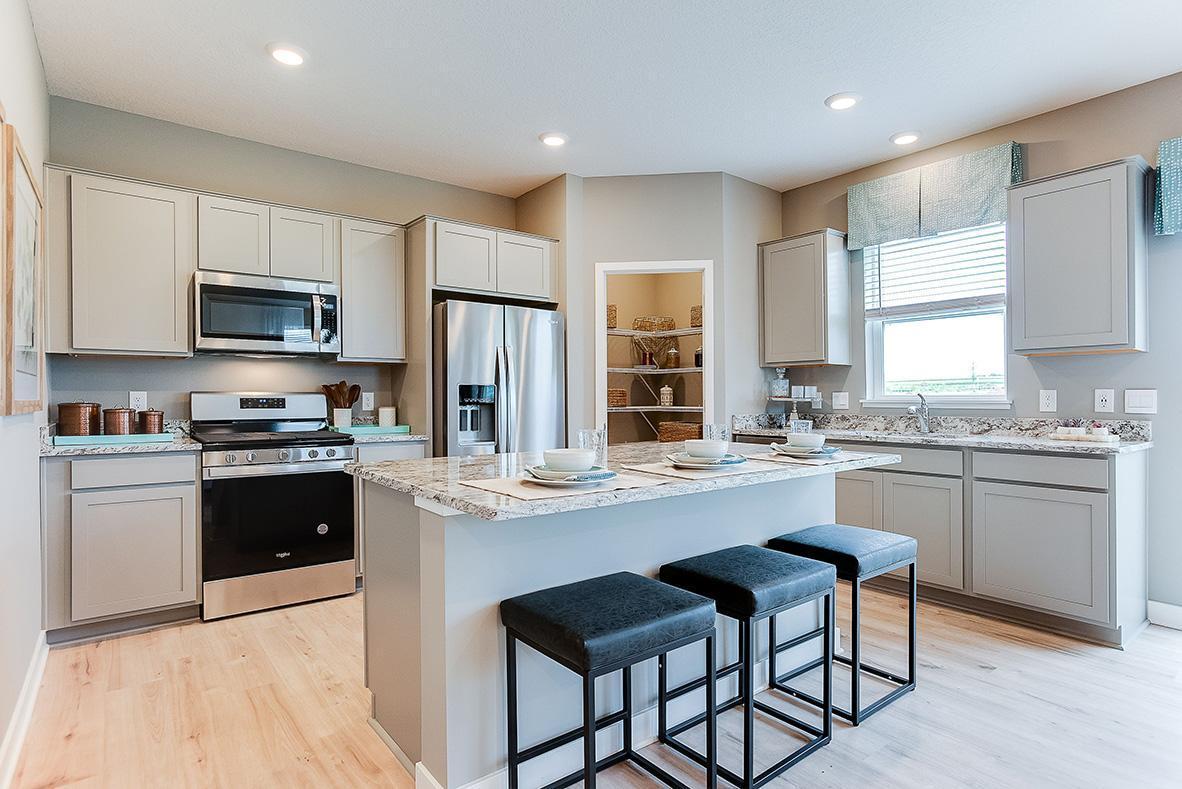 A kitchen built to perform - complete with an oversized island, pantry closet, stainless appliance package including a vented microhood and gas range, and enough space throughout for the family chef to roam about!