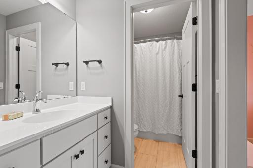 Featuring a large vanity, tile floors and a compartmentalized tub/shower and toilet, the en-suite bath offers convenience and privacy.
