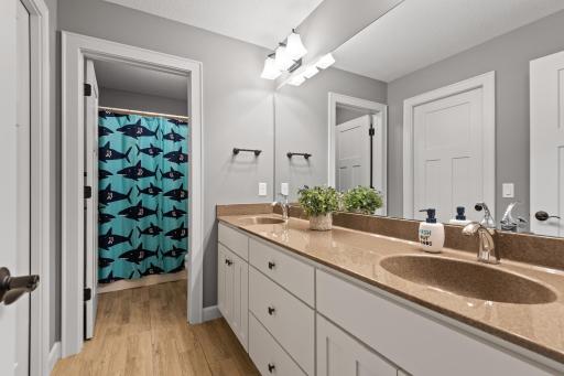 The Jack-and-Jill bathroom has a dual vanity and compartmentalized shower and toilet.