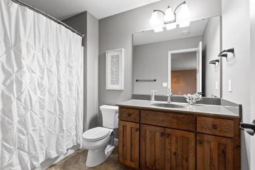 The shared lower level bathroom features a lovely vanity with plenty of storage and a large tub/shower.