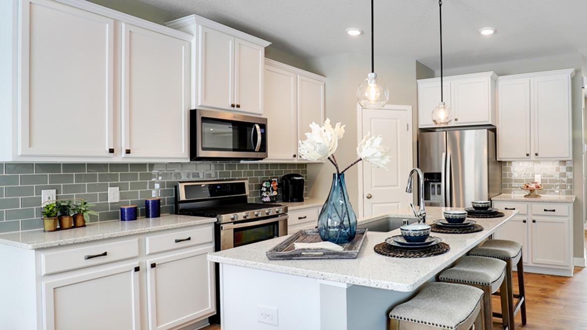 The kitchen is one of performance, and will feature Quartz countertops, stunning backsplash, rustic durable flooring, a walk-in pantry and stainless steel appliances. Just an awesome set-up! Photo of model home, color and options will vary.