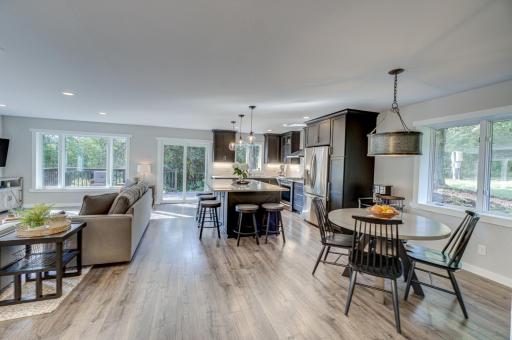 The home features a fully remodeled open-concept kitchen, dining, and living area with oversized windows, all-new flooring, a huge granite kitchen island, and all new stainless-steel appliances.