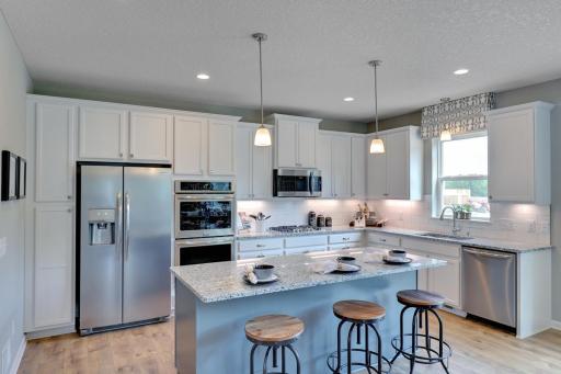 The kitchen includes stainless steel appliances, double ovens, kitchen window over the sink.
