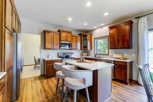 Beautiful, warm and open kitchen with stainless steel appliances, center island, rich cabinetry and breakfast area.